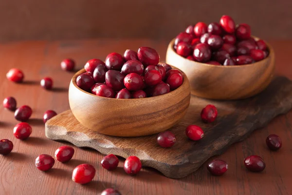 Fresh cranberry in wooden bowls over rustic table — Stock Photo, Image