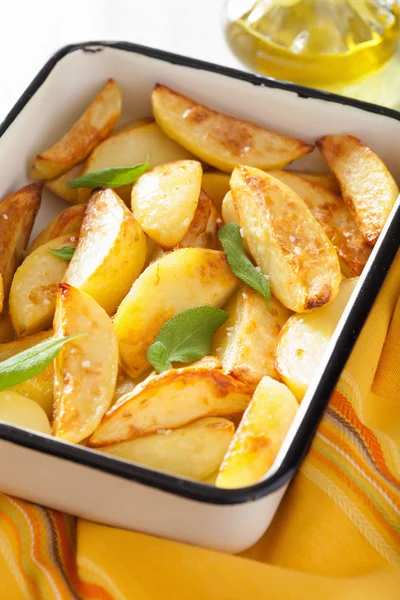 Cuñas de patata al horno en plato para hornear de esmalte —  Fotos de Stock