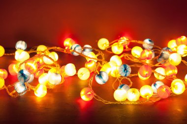 kırmızı bir arka plan üzerinde yanan Noel ışıkları 