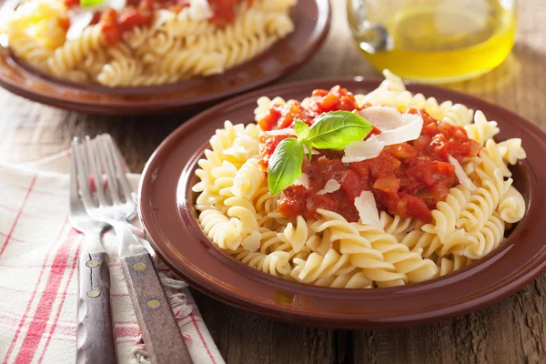 Klasické italské těstoviny fusilli s rajčaty a bazalkou — Stock fotografie