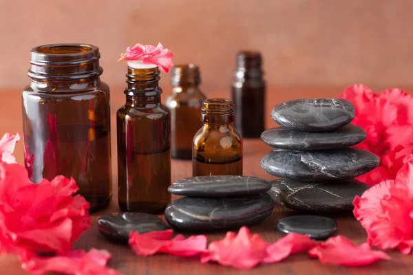 Essential oil azalea flowers black massage stones — Stock Photo, Image