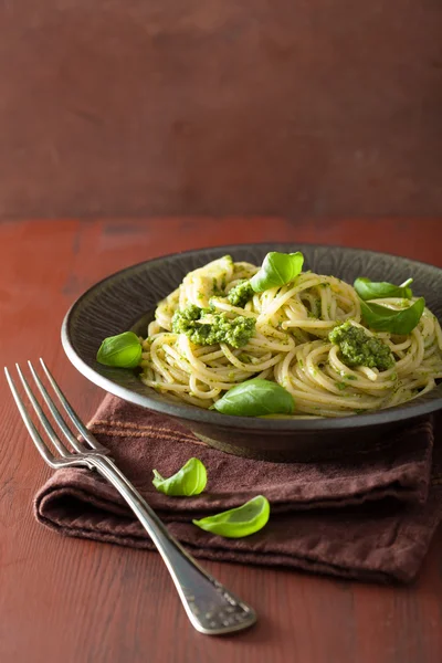 Pasta de espaguetis con salsa de pesto sobre mesa rústica —  Fotos de Stock