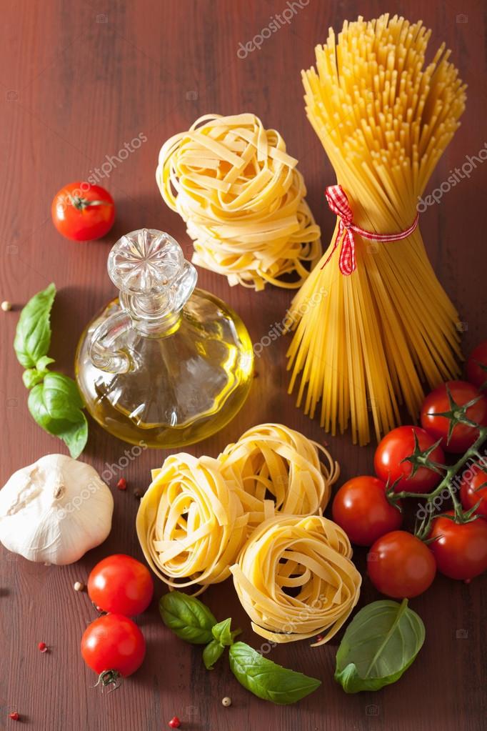 Raw pasta olive oil tomatoes. italian cooking in rustic kitchen Stock