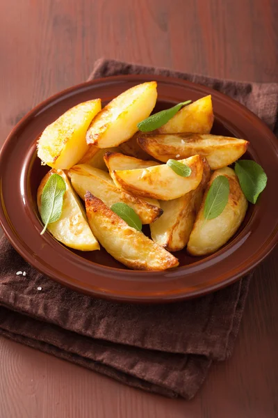 Cunei di patate al forno in piatto su tavolo rustico marrone — Foto Stock