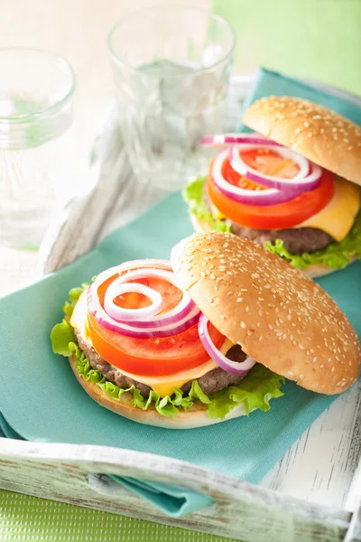 Cheeseburger med oksekød patty ost salat løg tomat - Stock-foto