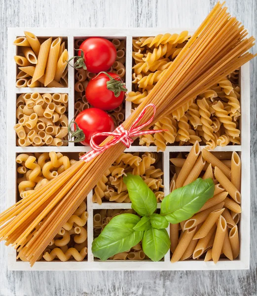 Various raw wholegrain pasta in white wooden box — Stock Photo, Image