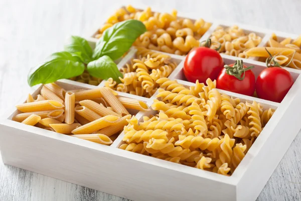 Various raw wholegrain pasta in white wooden box — Stock Photo, Image