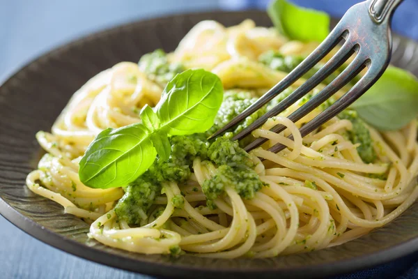 Makaron spaghetti z sosem pesto nad niebieski — Zdjęcie stockowe