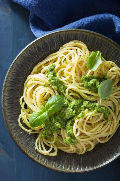 Macarrão de espaguete com molho de pesto sobre azul — Fotografia de Stock