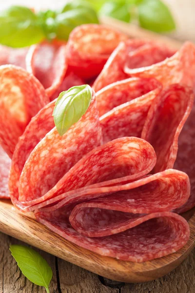 Fette di salame in piatto di legno — Foto Stock