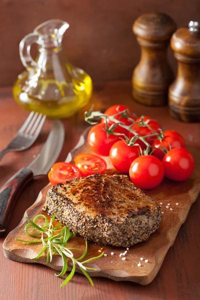 Rindersteak mit Gewürzen und Rosmarin auf Holzgrund — Stockfoto