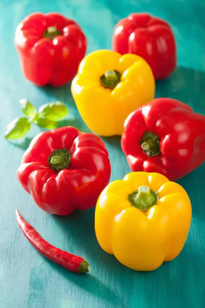 Pimentas amarelas vermelhas vegetais saudáveis em fundo turquesa — Fotografia de Stock