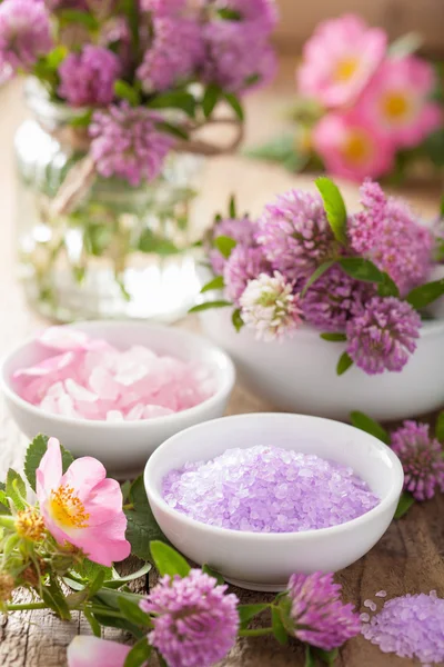 Spa con sal de hierbas rosadas y flores de rosas silvestres trébol — Foto de Stock