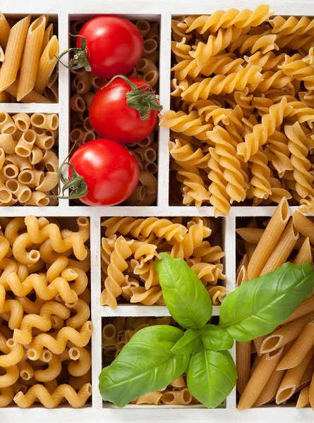 Various raw wholegrain pasta in white wooden box — Stock Photo, Image