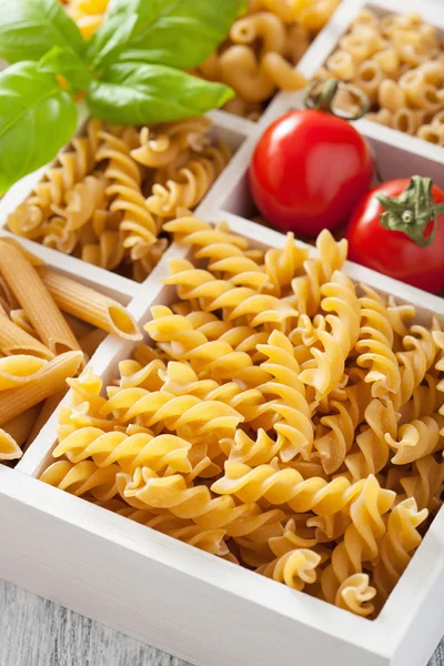 Various raw wholegrain pasta in white wooden box — Stock Photo, Image