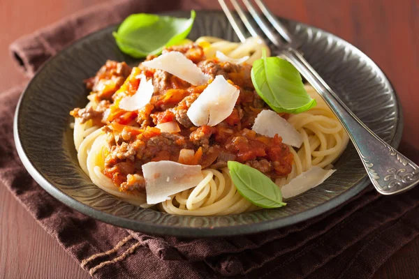 Pasta italiana espaguetis boloñesa con albahaca sobre mesa rústica —  Fotos de Stock