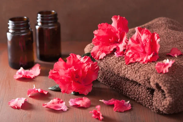 Spa bathroom with azalea flowers essential oil on dark rustic ba — Stock Photo, Image