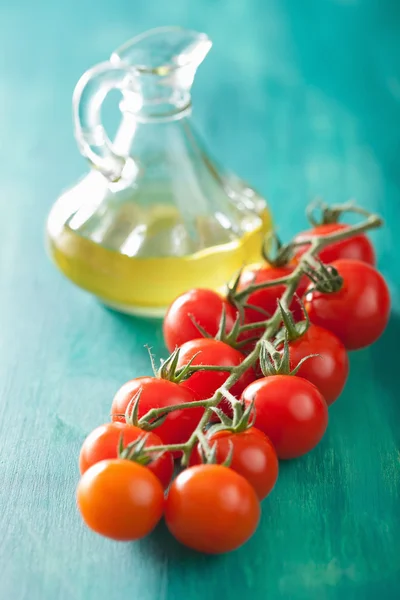 Tomates cherry y aceite de oliva sobre fondo turquesa —  Fotos de Stock