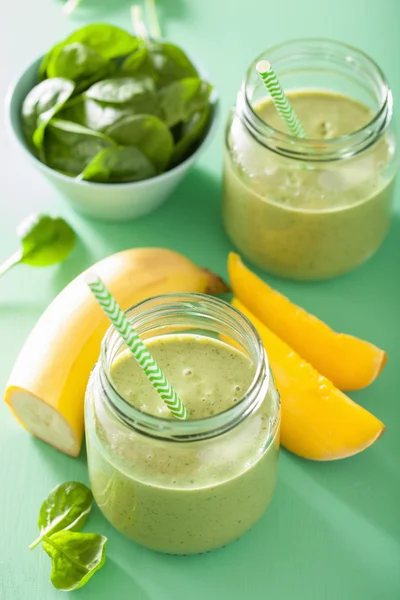 Frullato verde sano con banana di mango agli spinaci in barattoli di vetro — Foto Stock