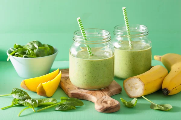 Healthy green smoothie with spinach mango banana in glass jars — Stock Photo, Image