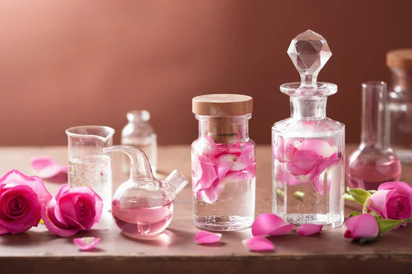 Alkemi och aromaterapi med rosa blommor och kolvar — Stockfoto