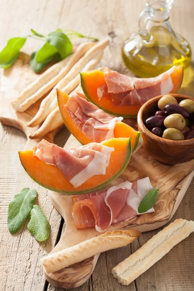 Cantaloupe melon with prosciutto grissini olives. italian appeti — Stock Photo, Image