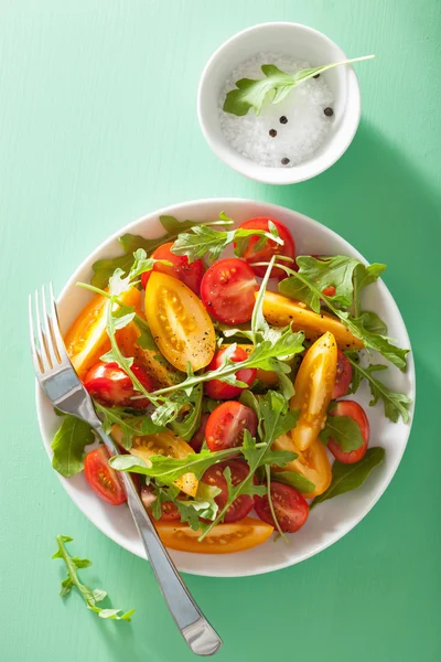 Salade de tomates avec roquette sur fond vert — Photo