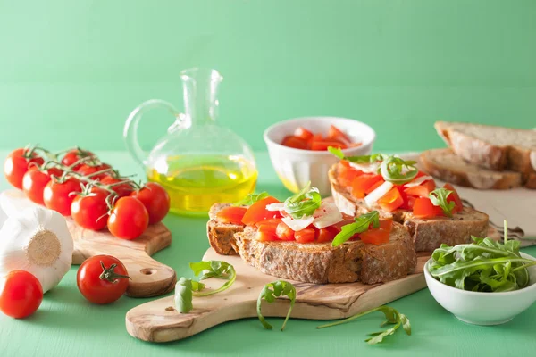 Italian bruschetta with tomatoes parmesan arugula — Stock Photo, Image