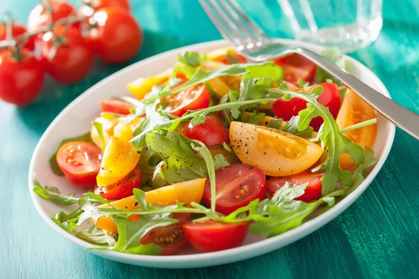 Salade de tomates avec roquette sur fond vert — Photo