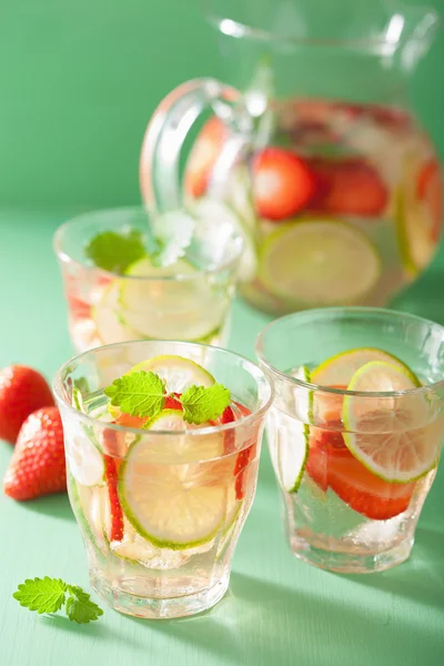 Boisson rafraîchissante d'été avec de la fraise concombre citron vert dans un pot et — Photo