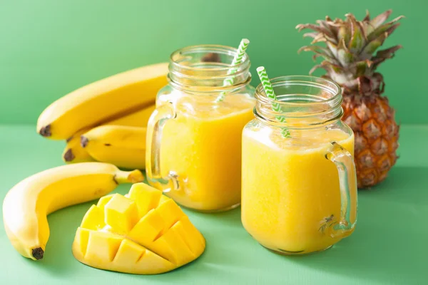 healthy yellow smoothie with mango pineapple banana in mason jar