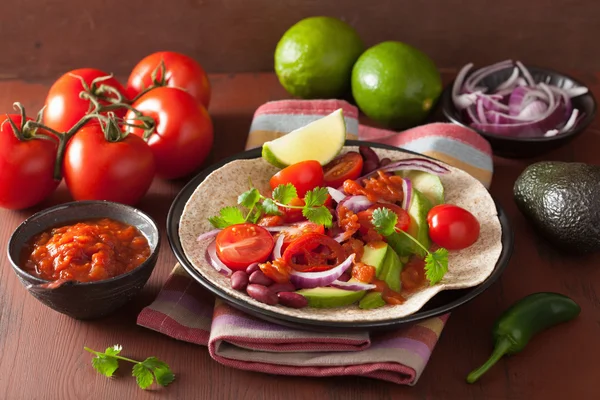 Vegansk taco med avocado tomat nyrebønner og salsa - Stock-foto