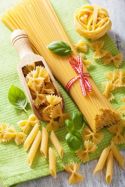 Pasta cruda spaghetti farfalle penne, pomodori. cucina italiana — Foto Stock