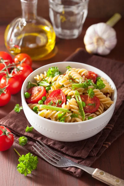 Vegetariánské těstoviny fusilli s bylinkami hrachu, rajčat — Stock fotografie