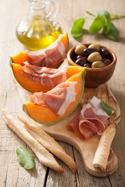 Melón melón con aceitunas prosciutto grissini. apeti italiano — Foto de Stock