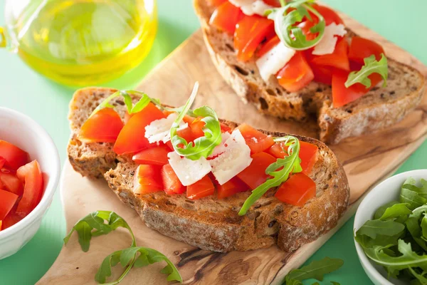 Italian bruschetta with tomatoes parmesan arugula — Stock Photo, Image