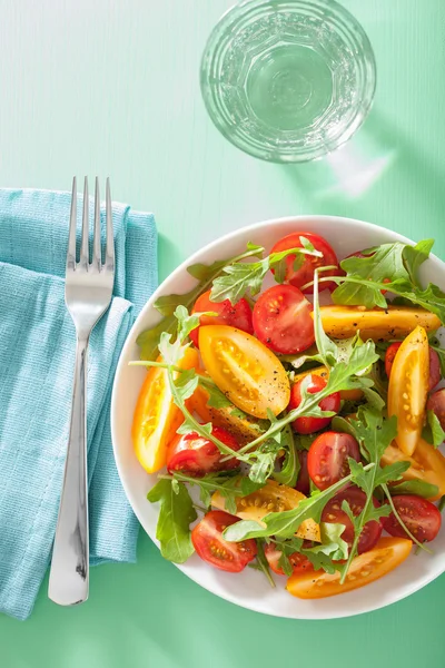 Salade de tomates avec roquette sur fond vert — Photo