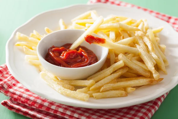 Pommes frites med ketchup över grön bakgrund — Stockfoto