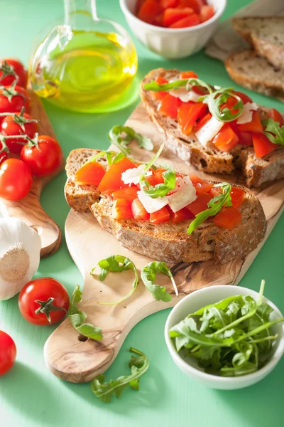 Bruschetta italiana con rúcula de parmesano de tomates — Foto de Stock