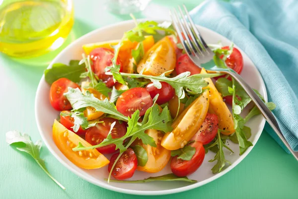 Tomatensalade met rucola op groene achtergrond — Stockfoto