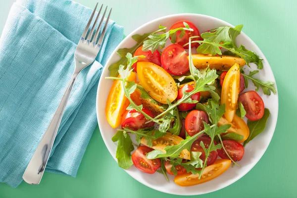 Salade de tomates avec roquette sur fond vert — Photo