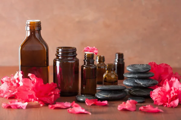 Essential oil azalea flowers black massage stones — Stock Photo, Image