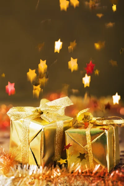 Stars decoration falling over christmas gifts — Stock Photo, Image