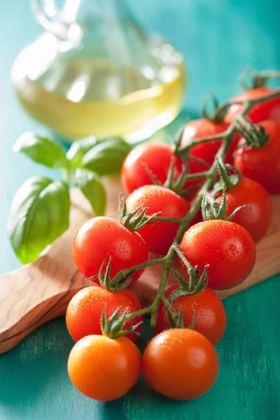 Tomates cherry y aceite de oliva sobre fondo turquesa —  Fotos de Stock