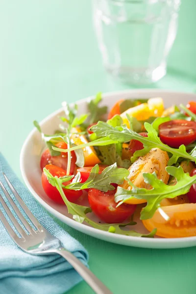 Tomatensalade met rucola op groene achtergrond — Stockfoto