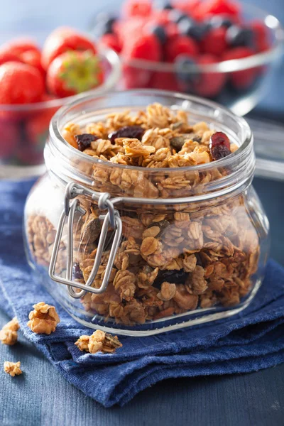 Homemade healthy granola in glass jar and berries — Stock Photo, Image