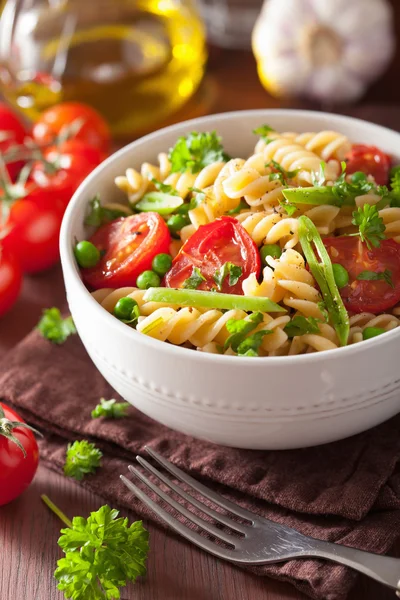 Vegetariánské těstoviny fusilli s bylinkami hrachu, rajčat — Stock fotografie