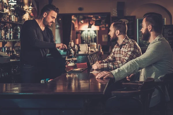 Amis boire de la bière pression au comptoir du bar au pub . — Photo