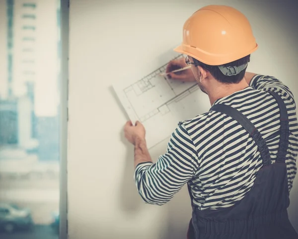 Capataz con plan de construcción en el interior del edificio nuevo — Foto de Stock