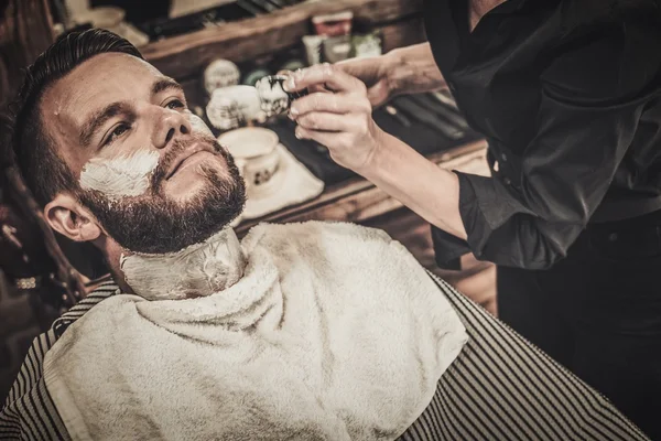 Klient podczas golenia brody w zakładzie fryzjerskim — Zdjęcie stockowe